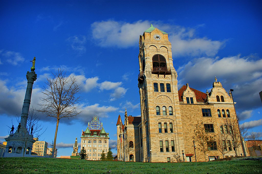 After walking around the streets north of the Municipal Building, we decide to go back and walk south and are treated by this huge, monolithic Lackawanna County Courthouse building sitting alone like a majestic castle in the middle of Veterans Plaza.
“The architectural style of the Courthouse is Victorian Gothic with Romanesque details. The building, like all of Scrantons early structures, is of locally-quarried West Mountain stone, trimmed with Onondaga limestone. Gothic details include the corner towers, carved stone details and ornamental buttresses. Romanesque details include the rounded arch windows and tower openings.”

(http://www.lackawannacounty.org/ViewEventDetails.aspx?EventID=162)