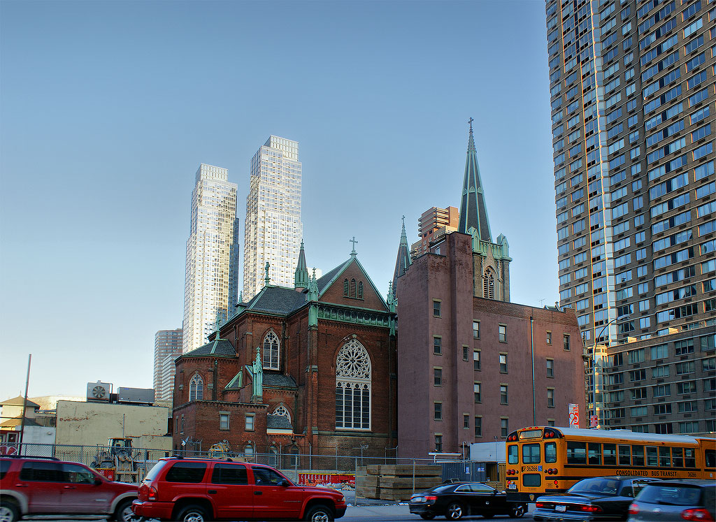Saint Raphael's Church.Saint Raphael's Roman Catholic Church on 41st Street and 10th Avenue was “established in 1886 to serve the Irish Catholics of Hell's Kitchen.”* From this angle it looks like the church's dominance of the area is being threatened by the buildings surrounding it. There's construction going on in the foreground on the 10th Avenue side which I'm sure the church is hoping is not going to be a skyscraper.From this angle it would seem that the church is partially blocked by the purple building....(*Source: http://www.nycago.org/Organs/NYC/html/SSCyrilMethodius.html)